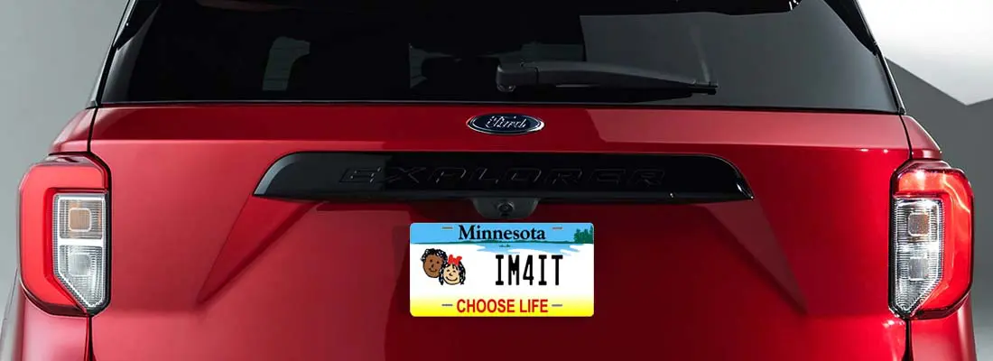 A minnesota license plate on the back of a red car.